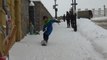 Snowboarders ride on city sidewalks after snowfall