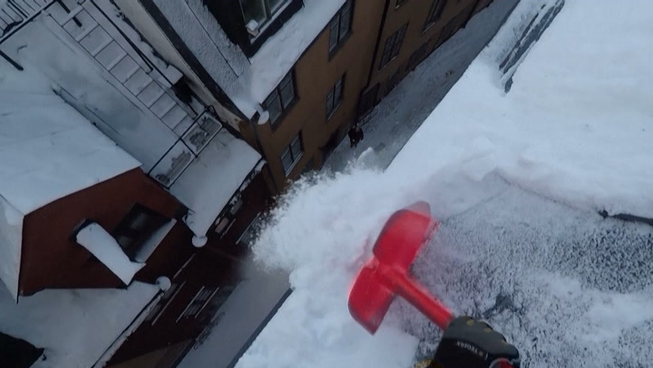 Rooftop snow sweepers brave dizzying heights in Stockholm