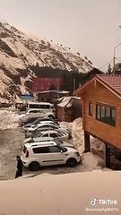 Une avalanche pousse des voitures sur un parking