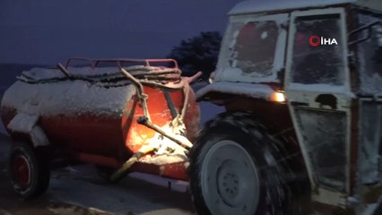 Karda mahsur kalan otomobili traktörle kurtarma operasyonu