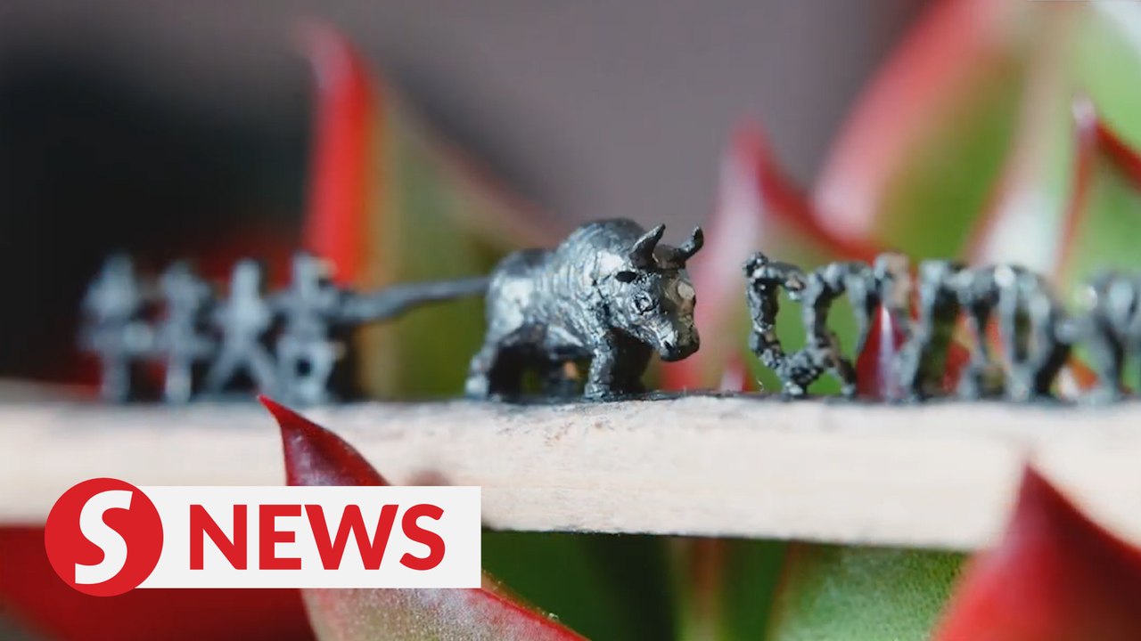 Young Chinese man carves microsculptures on pencil to celebrate Year of the Ox