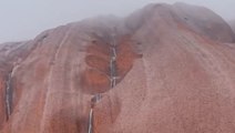 Rare rain cascades down Australia’s iconic Uluru monolith