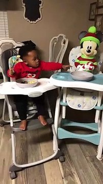 Ce petit enfant partage son repas avec mickey