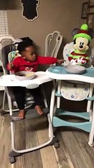 Ce petit enfant partage son repas avec mickey