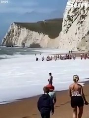 Incredible moment crowd forms human chain to rescue two swimmers from surf at Durdle Door