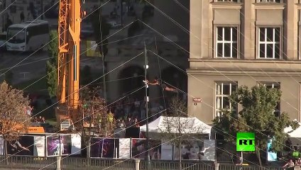 فتاة من فرنسا تجذب الأنظار بمشيها على حبل وسط العاصمة التشيكية