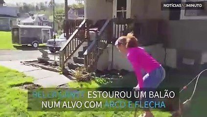 Menina estoura balão com arco e flecha de ponta-cabeça!