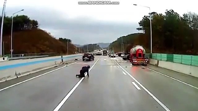 Un homme esquive des voitures sur une autoroute verglacée