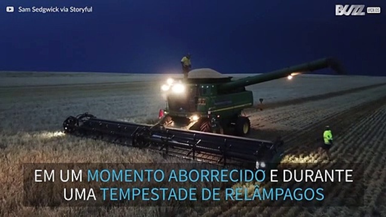 Homem dança em colhedeira durante tempestade de...