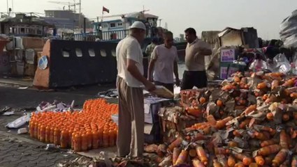 Workers clean up after a fire destroyed 3 dhows at Dubai‬ Creek
