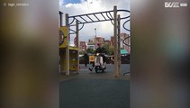 Strong man raises the bar by doing pull ups while attached to motor scooter