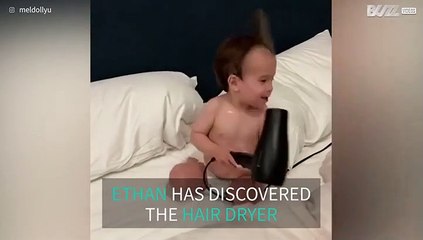 Kid can't get enough of playing with the hair dryer