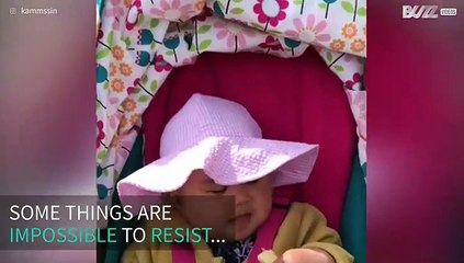 Youngster struggles with snack as sleepy feeling takes over