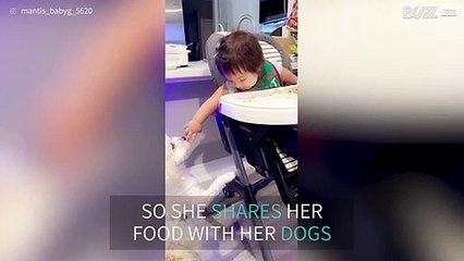 Baby shares food with her furry friends