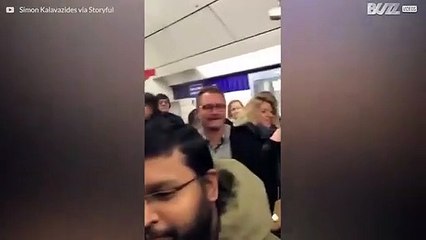 Väkijoukko laulaa yhteen ääneen Lontoon metroasemalla