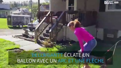 Elle éclate un ballon avec un arc et une flèche, en faisant l'équilibre!