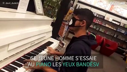 Un jeune homme joue du piano les yeux bandés