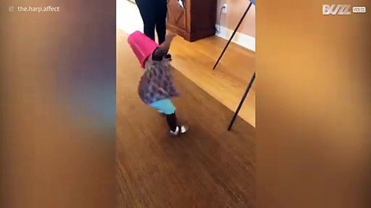 Questa bimba adora camminare con il secchiello in testa