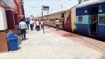 Migrant workers lunge for packaged drinking water before boarding train to go home