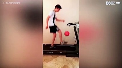 [TRANSLATE] - Young lad juggles soccer ball while walking treadmill