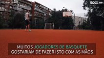 Jovem encesta bola de basquetebol com os pés