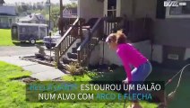 Menina estoura balão com arco e flecha de ponta-cabeça!