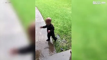 Criança se diverte na chuva pela primeira vez