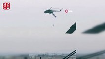 Askeri helikoptere takılan paraşütçü havada asılı kaldı
