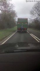 Cyclist Hitching a Ride Holding onto a Truck