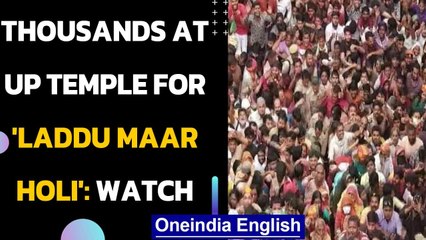 Скачать видео: UP: Thousands huddle for 'laddu maar Holi', few with masks with no social distancing| Oneindia News