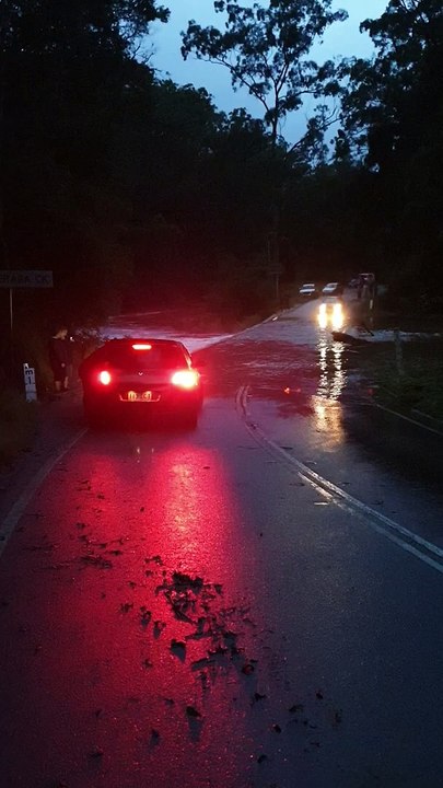 Une femme chute dans l'eau en marchant sur un pont pendant les inondation dans le Queensland