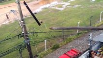 Torre de luz de campo de várzea cai, atinge casa e obstrui rua em BH