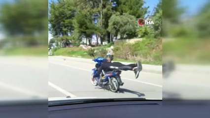 Yatarak tek elle motosiklet kullandı, kazaya davetiye çıkardı