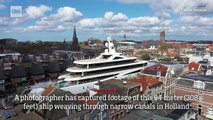 Huge superyacht squeezes through narrow canals