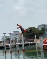 Two Dancers Practice Traditional Chinese Lion Dance Over Poles in Water