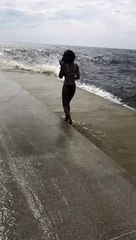 Lady Posing for Picture Surprised by Big Wave