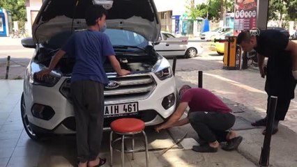 Aracın motor kısmına sıkışan kedinin çıkması için vatandaşların yapmadığı kalmadı