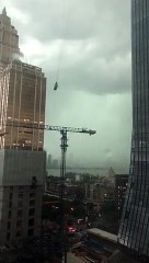 Des travailleurs piégés sur une plateforme suspendue lors d'une tempête de pluie
