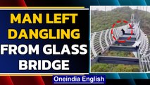 China: Man left dangling from 100 m high glass bridge | Oneindia News