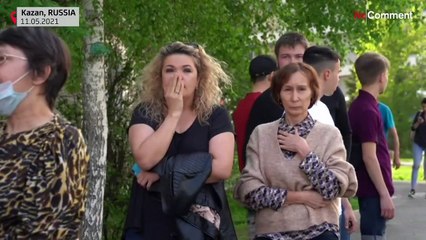 People lay flowers and soldiers stand guard outside Kazan school