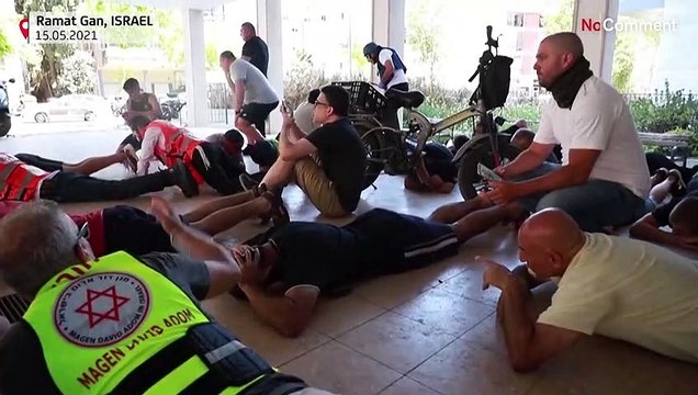 People take cover as sirens warn of incoming rocket on Ramat Gan