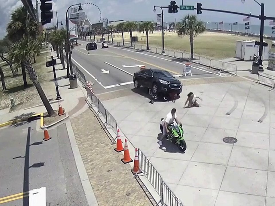 États-Unis: Des passants viennent aider un motard coincé sous la voiture !