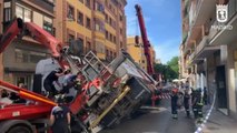 Los bomberos consiguen recuperar con una grúa un camión en el centro de Madrid