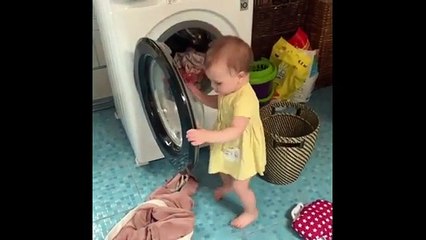 Precious baby helps her mom with the laundry