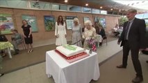 La reina Isabell II corta una gran tarta con una espada en un evento solidario en Reino Unido