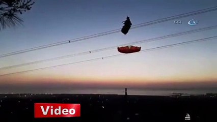 Tellere takılan paraşütçü helikopterin rüzgarıyla yere düştü