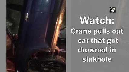 Crane pulls out car that got drowned in sinkhole