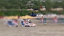 Vatandaşlar denize girdiği sırada plaja inen helikopter merak konusu oldu