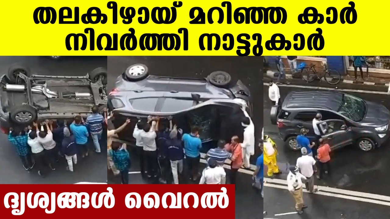 People helping overturned car back to it's wheel