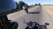 Biker Attempting Wheelie Falls Backwards While His Bike Slides Down the Road
